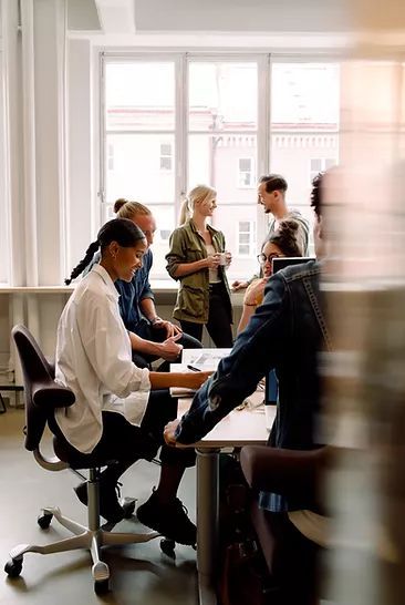 A group of people talking around a table in a bright room